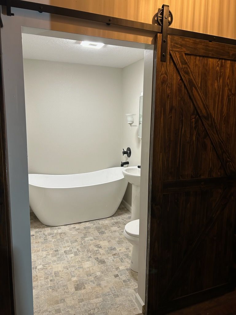 Side-by-side comparison of a bathroom: one side shows the finished space, and the other shows the studs and insulation.