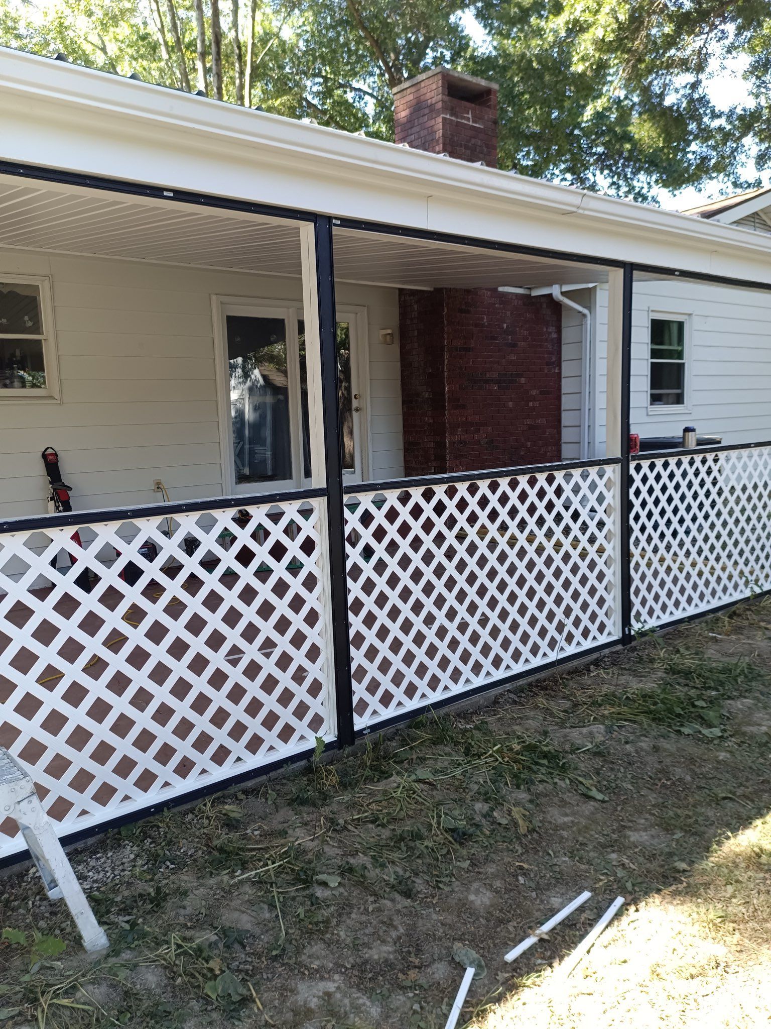 A white fluted porch column with a circular inset showing wood rot and peeling paint in the crevices.