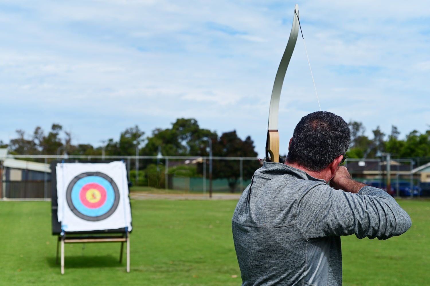 A Man is Aiming a Bow at a Target in a Field — Mackay Shooters Supplies in Proserpine, QLD