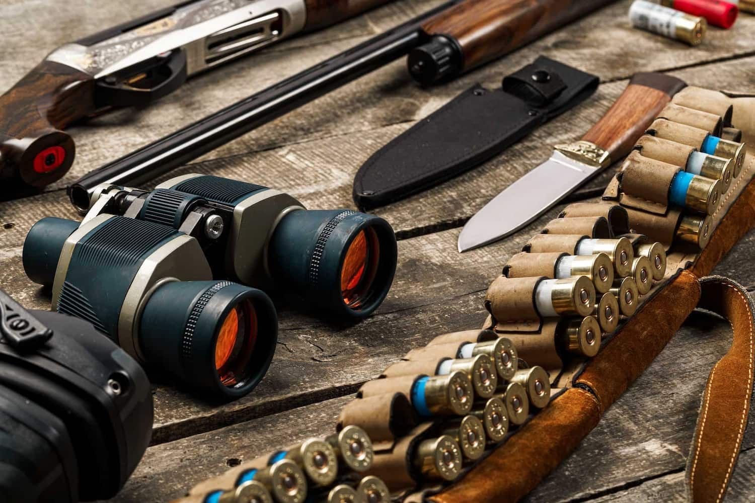 Laid Out on a Rustic Wooden Surface Are a Hunting Rifle, Binoculars, a Knife — Mackay Shooters Supplies in Mount Isa, QLD