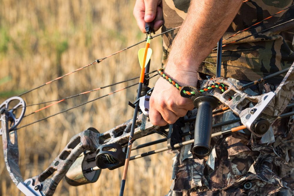 A Person in Camouflage Prepares to Shoot a Hunting Bow — Mackay Shooters Supplies in Emerald, QLD