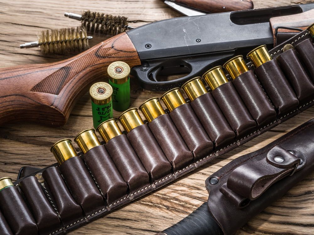 Close-up of a Shotgun, Wood Stock Visible, and Brown Leather Belt — Mackay Shooters Supplies in Proserpine, QLD