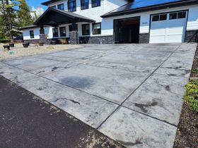 ow-pressure soft washing a home’s Driveway in Tigard, safely removing dirt and algae.