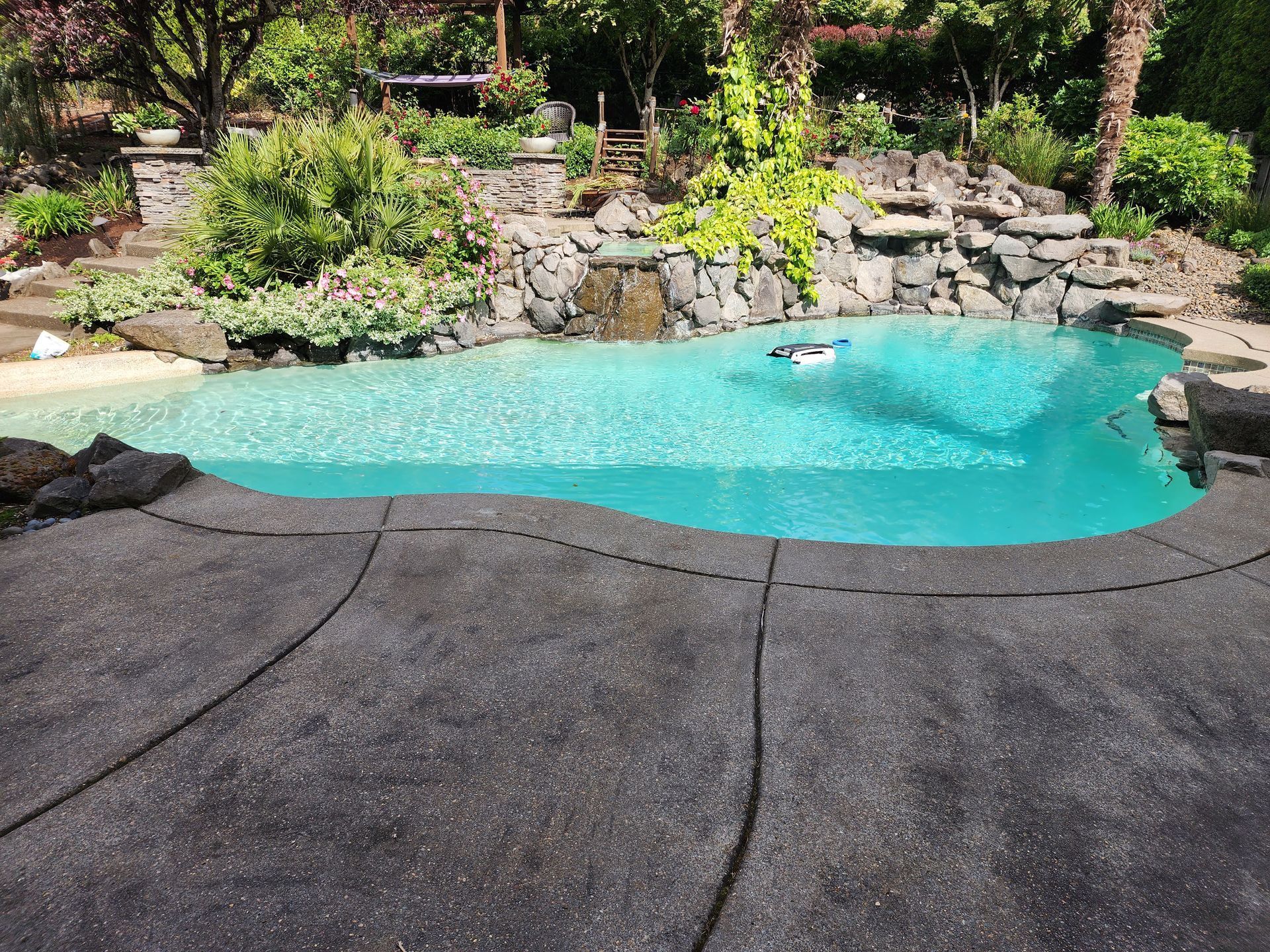 High-pressure hot water cleaning a concrete driveway, removing dirt and grime in Tigard Oregon