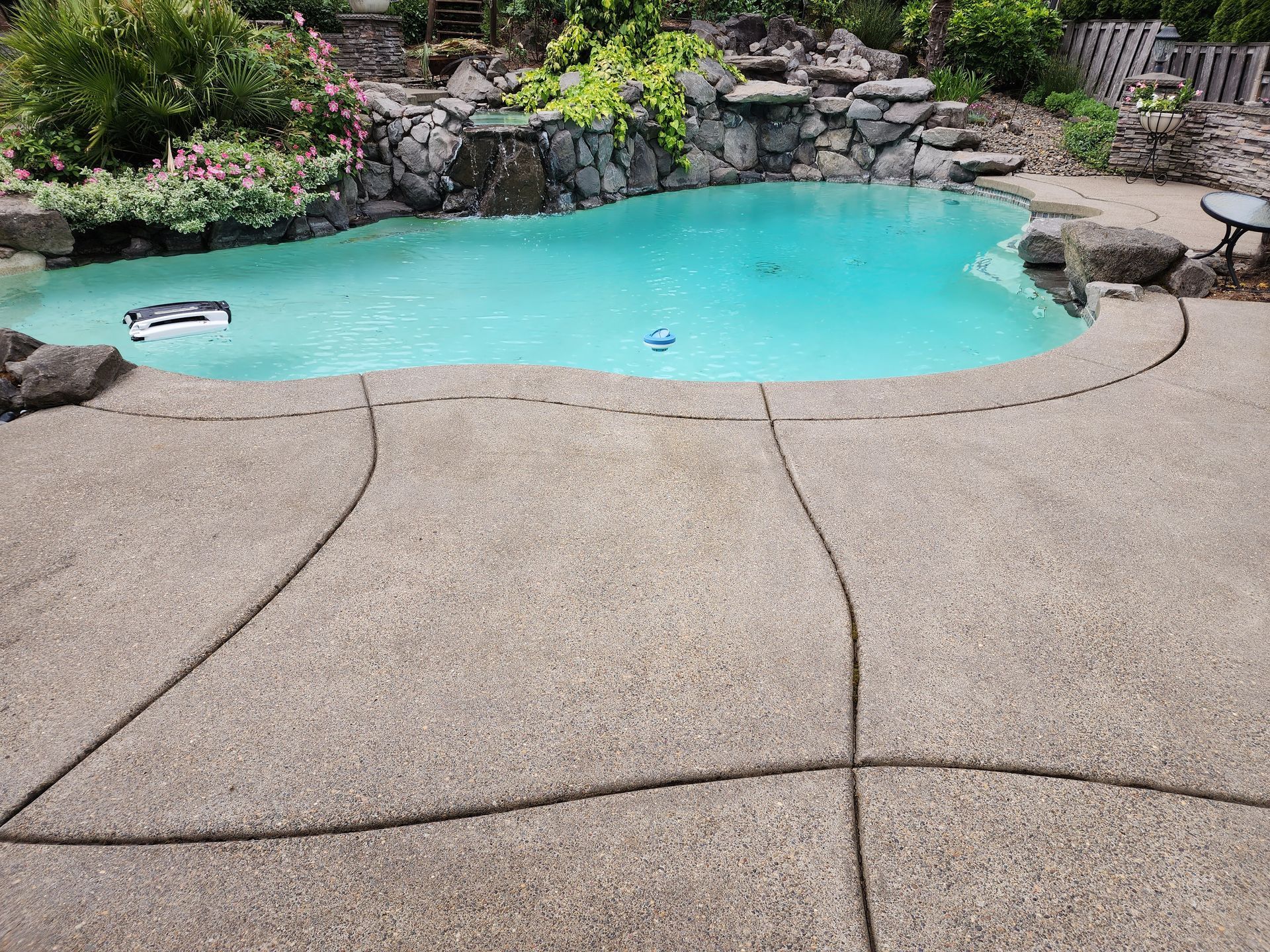 High-pressure hot water cleaning a concrete driveway, removing dirt and grime in Tigard Oregon