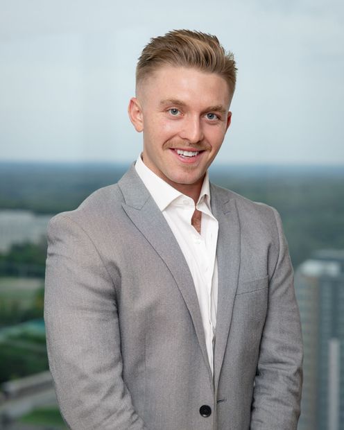 A man and a woman are sitting on a dock overlooking a lake.