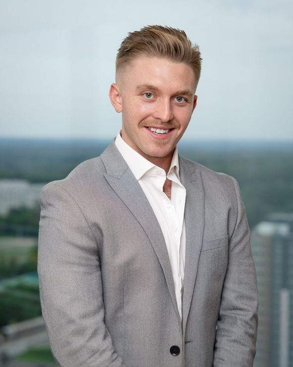 A man is holding a dog in his arms and the dog is wearing a sweater.