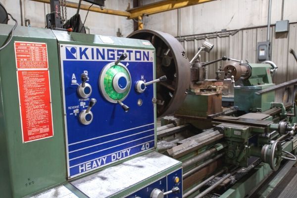 Blue and green Kingstong heavy-duty lathe in an industrial workshop