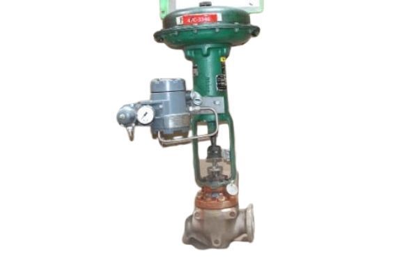 Green industrial valve actuator mounted on a metal valve assembly with gauges and red base