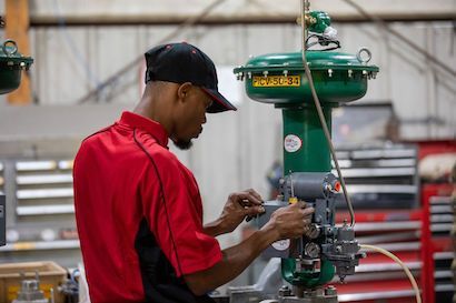 Worker in a red shirt adjusting machinery in a workshop