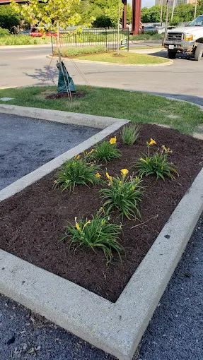 There is a statue of liberty in the middle of a garden.