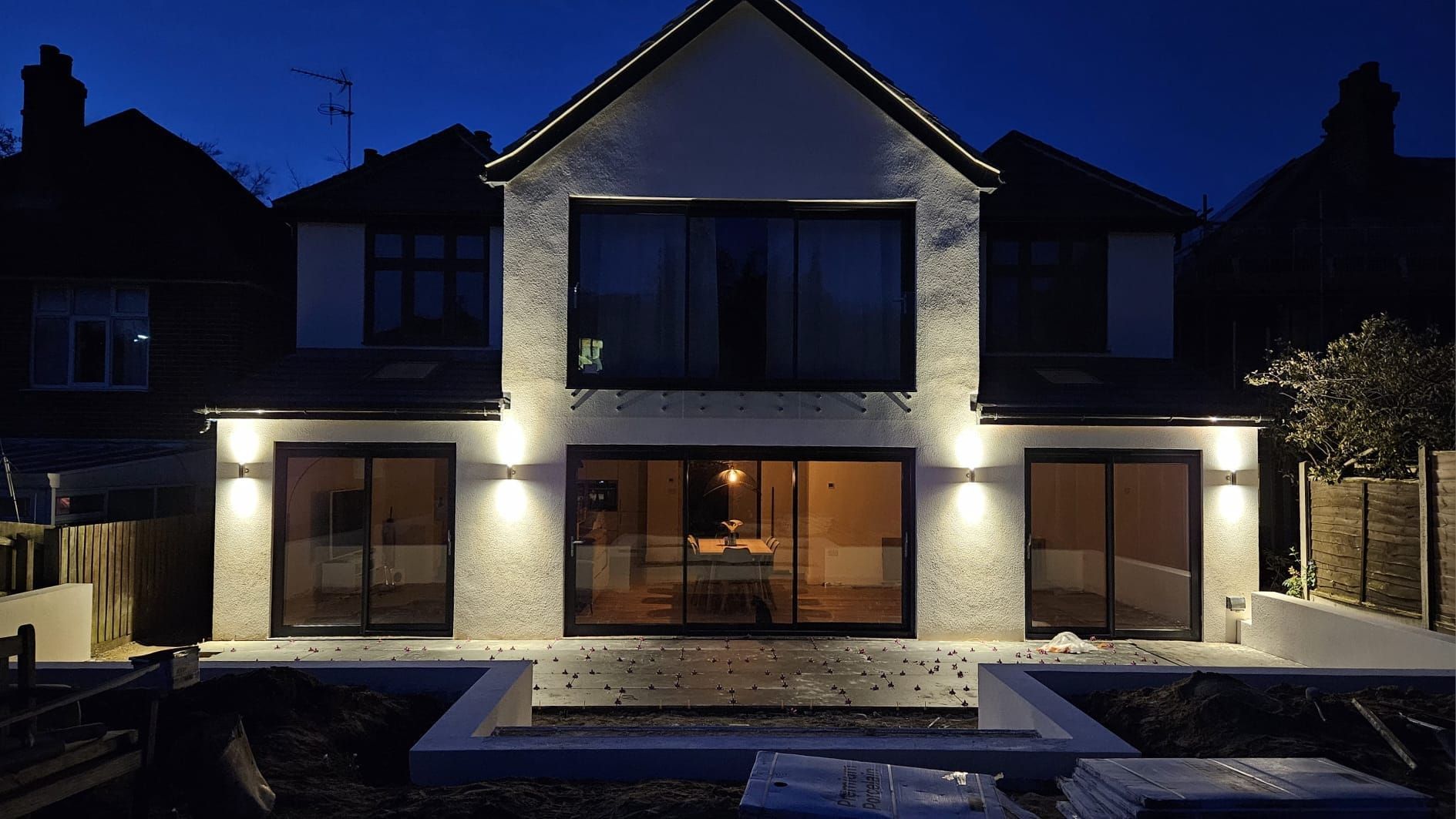 Showing a large two storey rear extension to a Suffolk property, lit up at night. Built by Pro Build East Ltd.