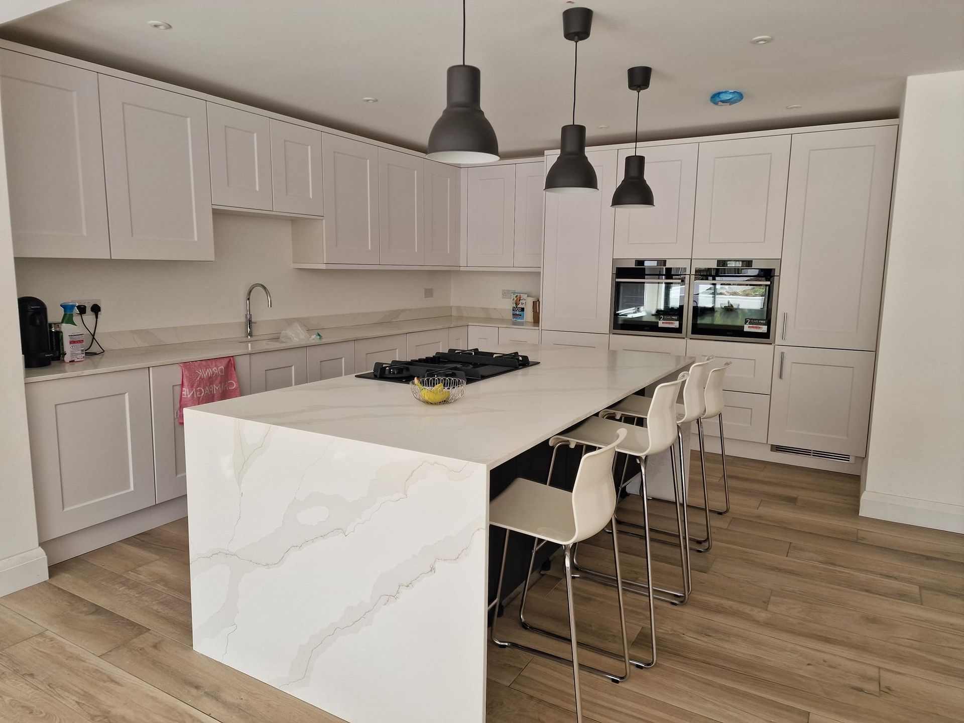 A newly renovated kitchen with white cabinets and a large island in the middle in Suffolk. Built by Pro Build East Ltd.