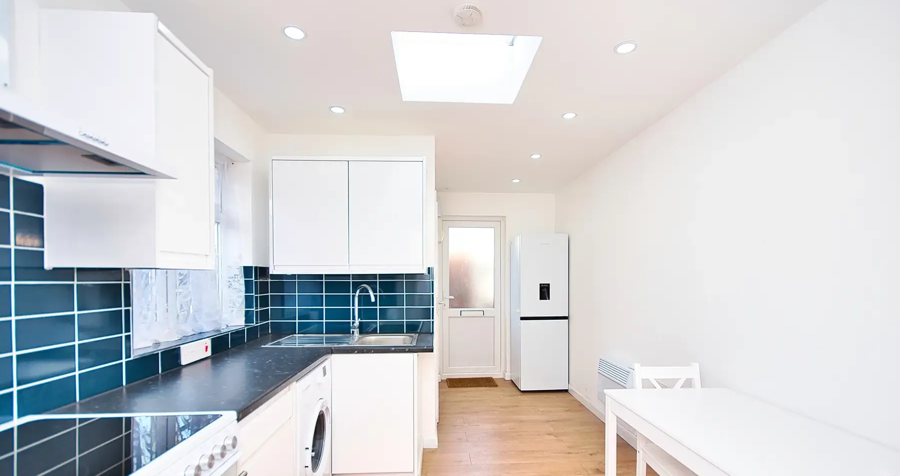 Garage conversion in Suffolk by Pro Build East Ltd transformed into a bright, modern, and simple kitchen with sleek finishes and natural lighting