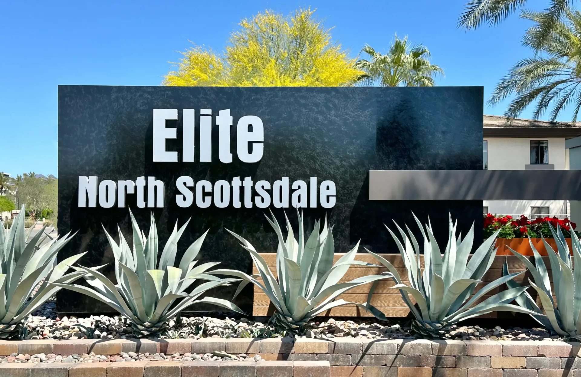 A large black sign that says elite north scottsdale