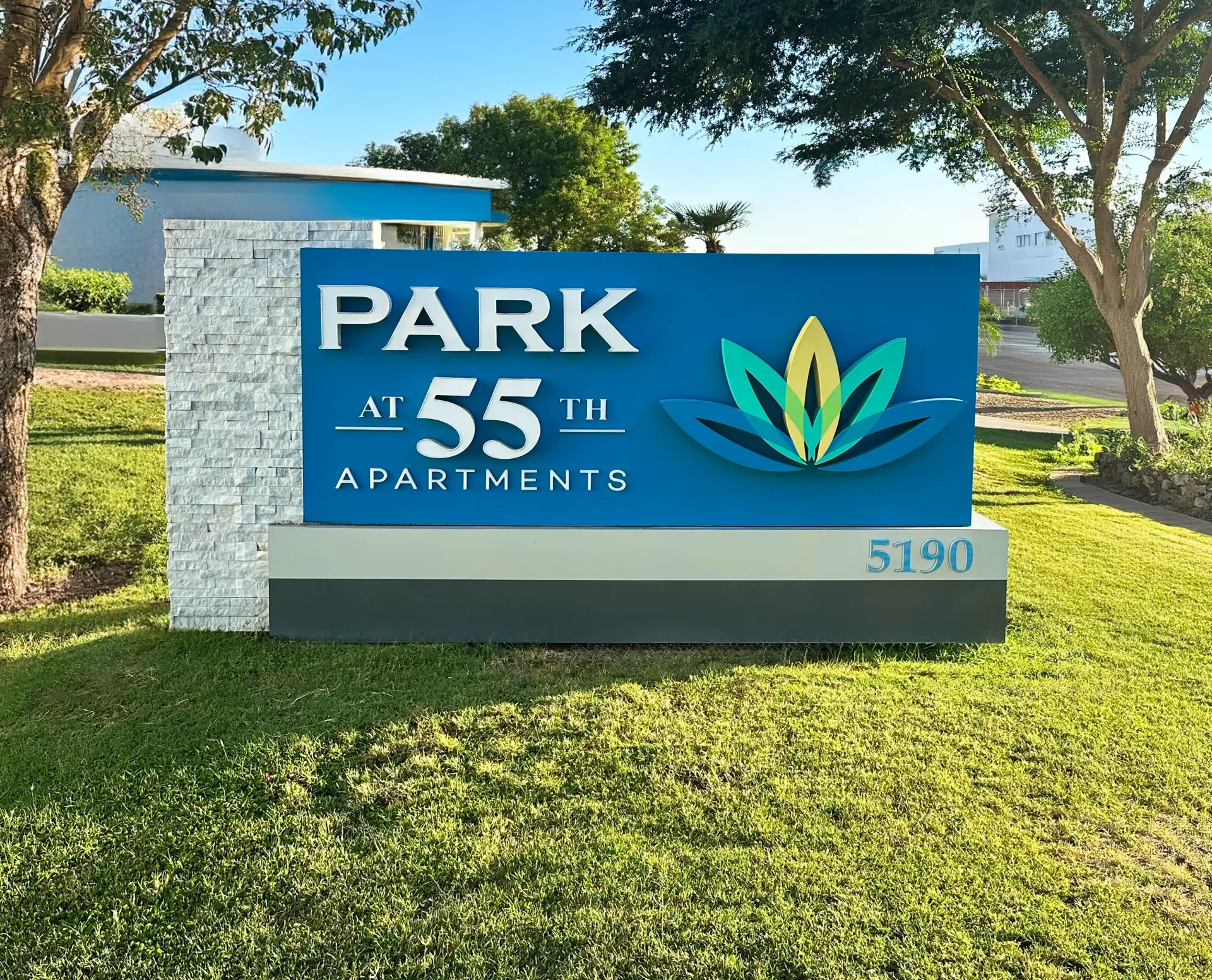 A blue and white sign for park 55th apartments