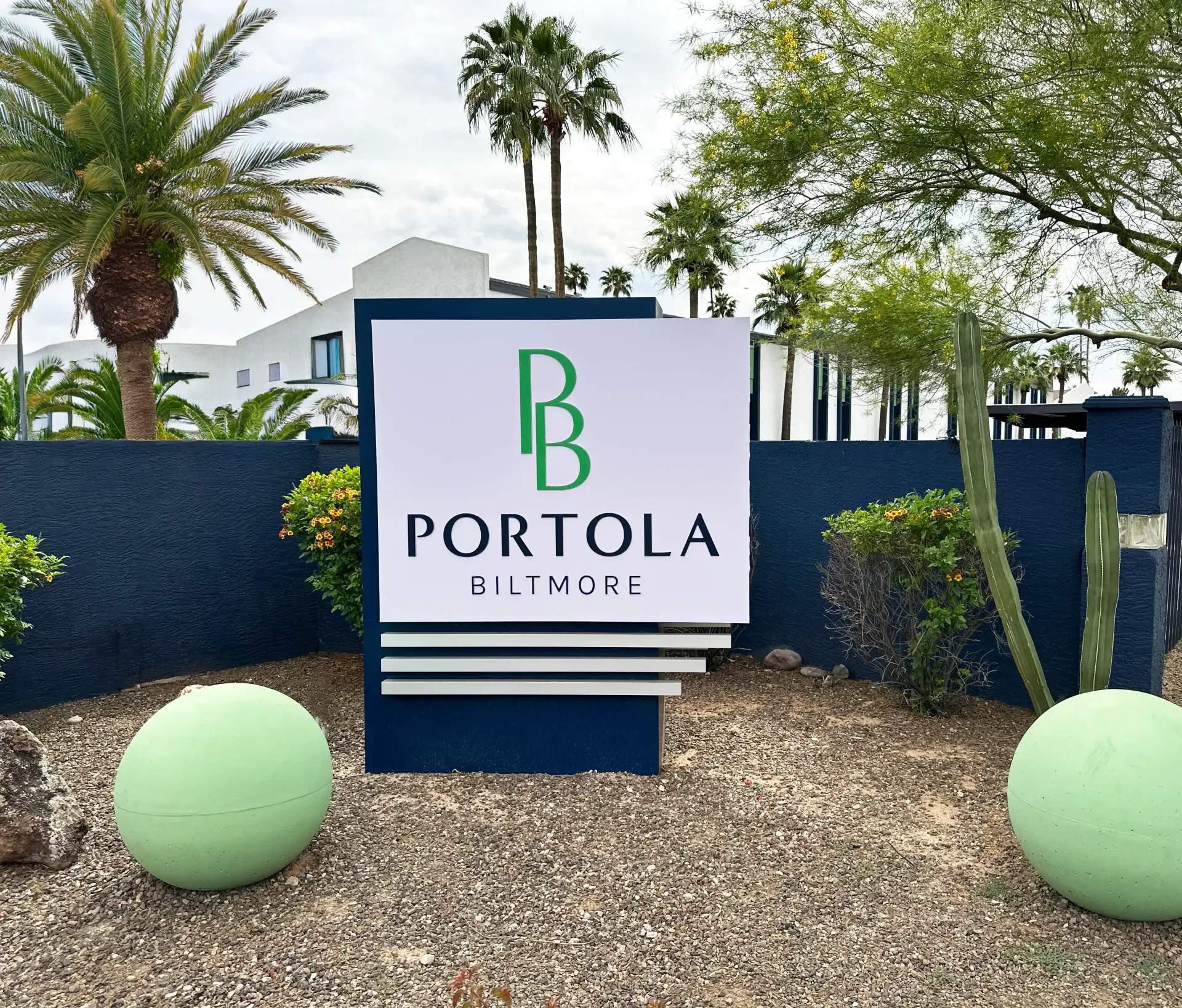A sign for portola sits in front of a blue wall