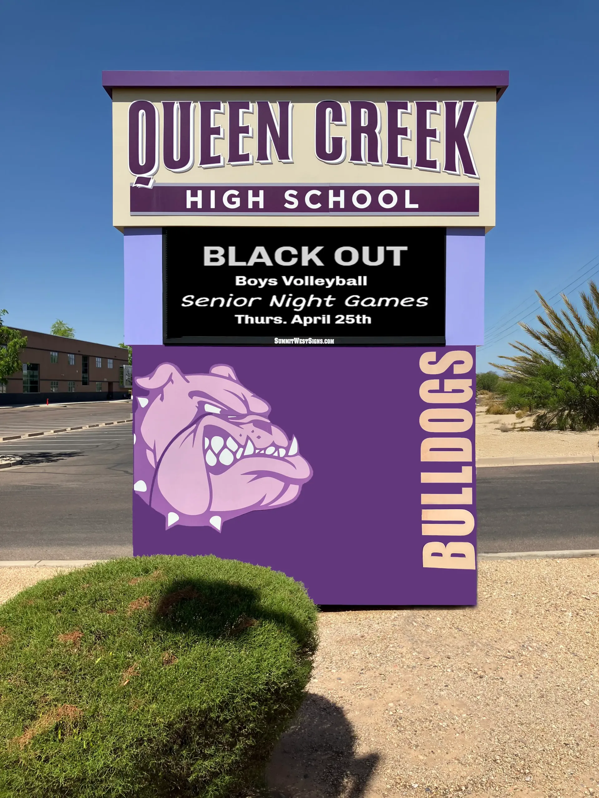 A sign for queen creek high school with a purple bulldog on it.