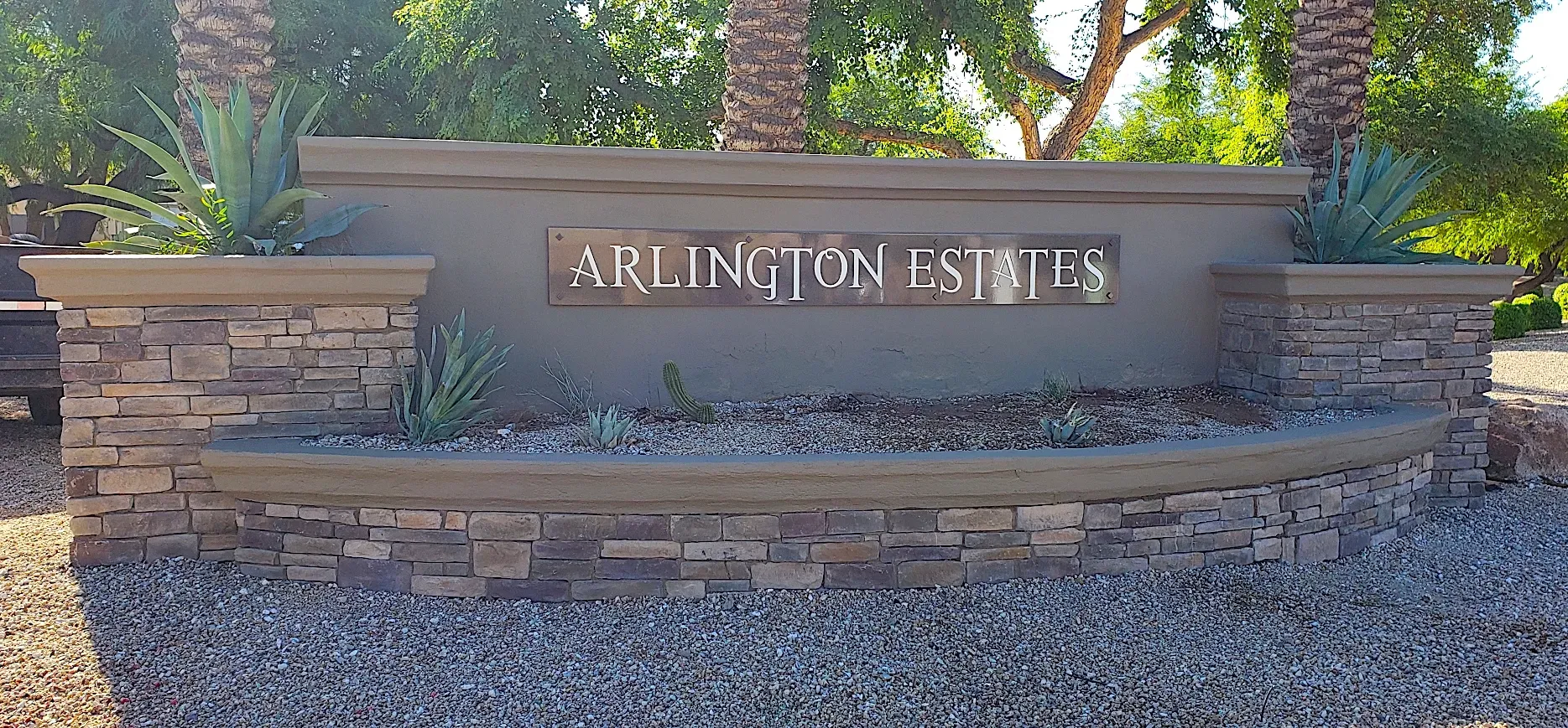 A stone wall with a sign that says arlington estates