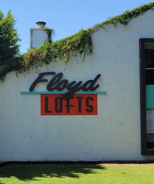 A white building with a sign that says floyd lofts