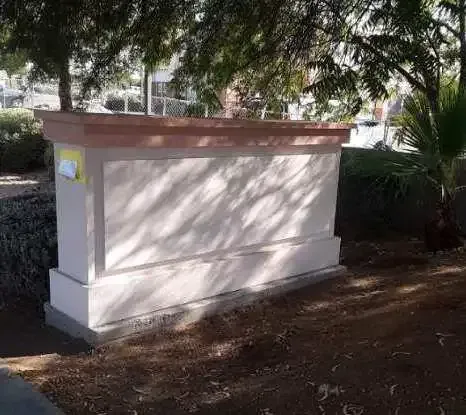 A large white box is sitting in the middle of a park.