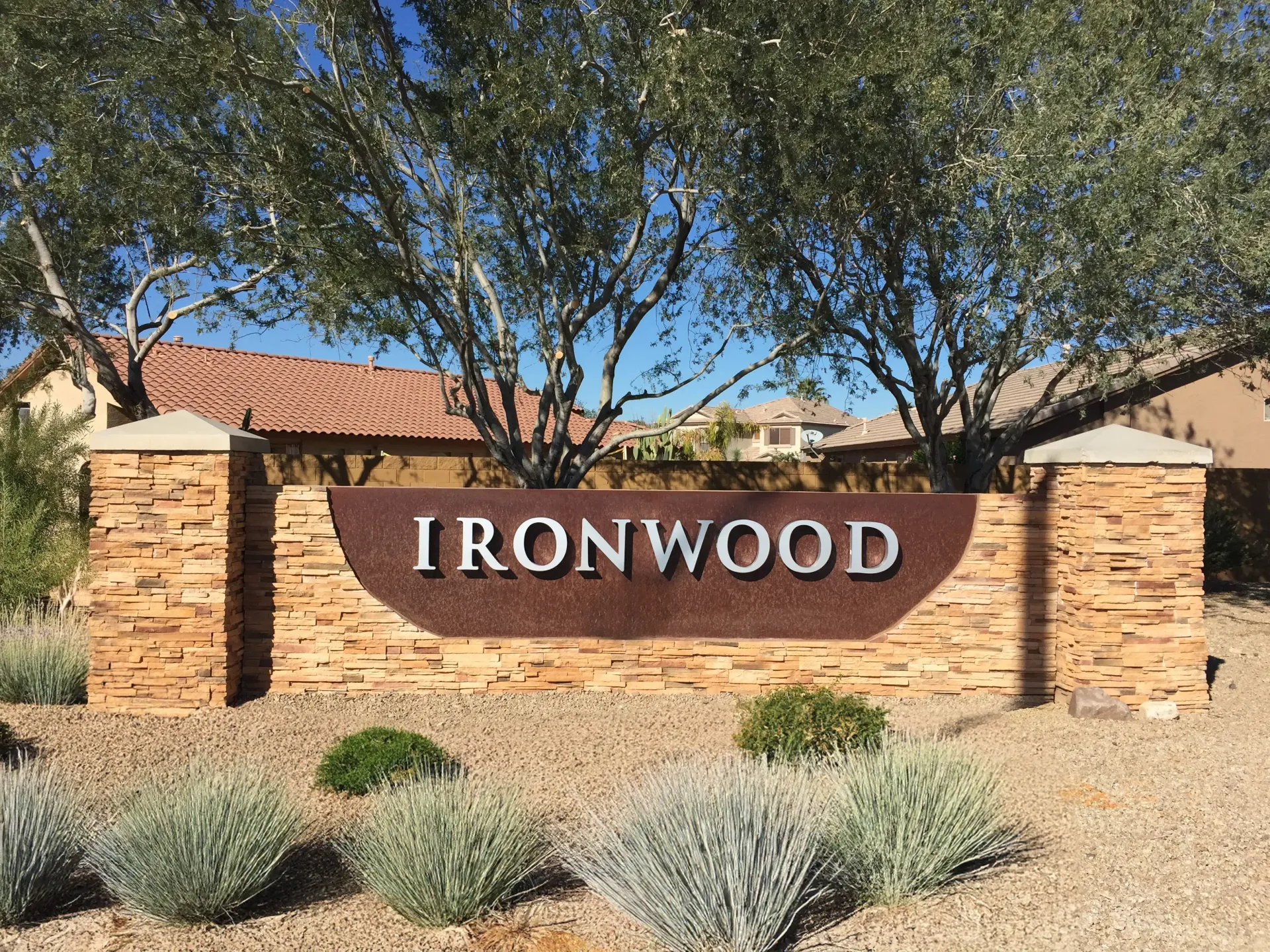 A sign for ironwood is sitting in front of a house.