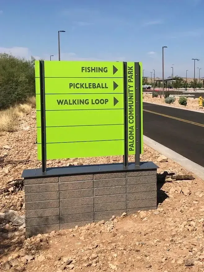 A yellow sign that says fishing pickleball and walking loop