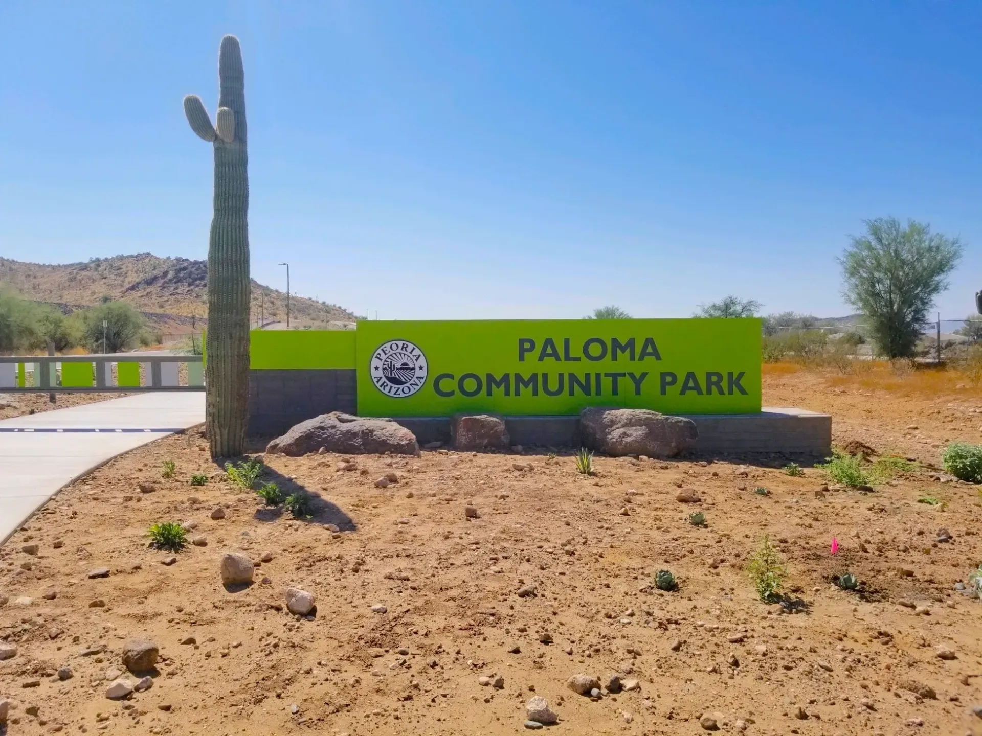 A green sign that says paloma community park