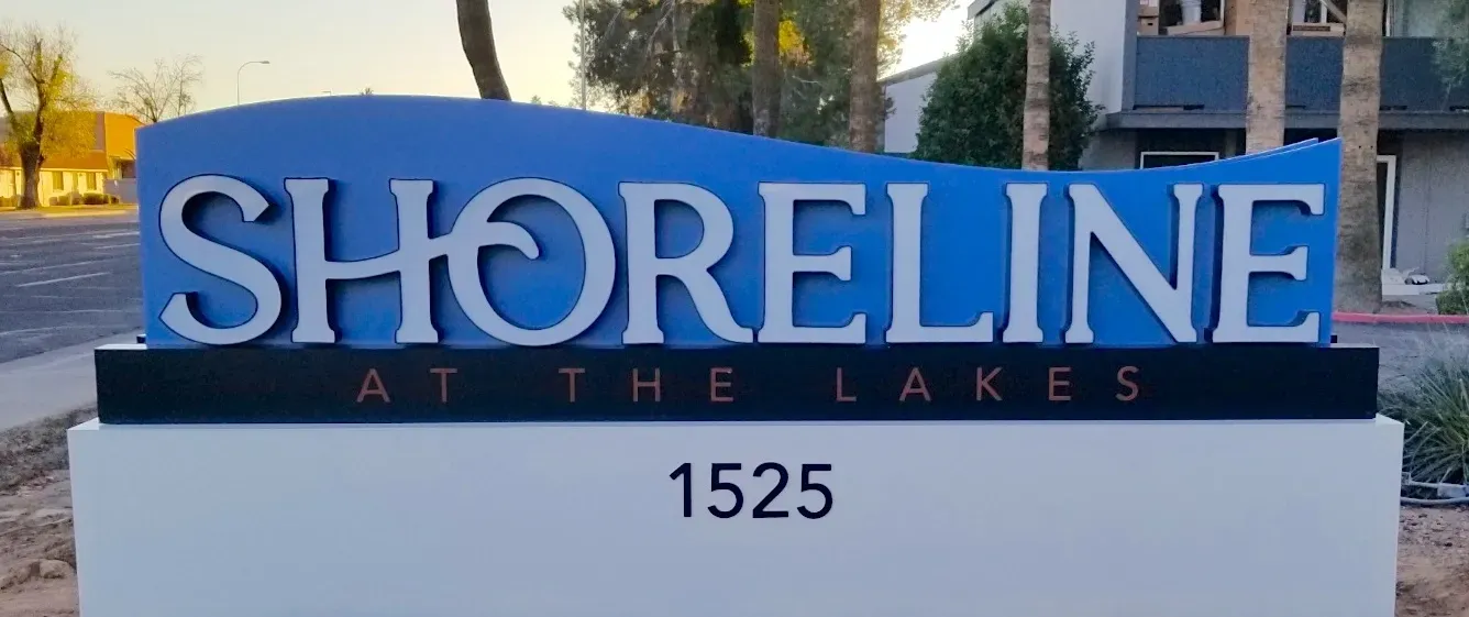 A blue and white sign for shoreline at the lakes