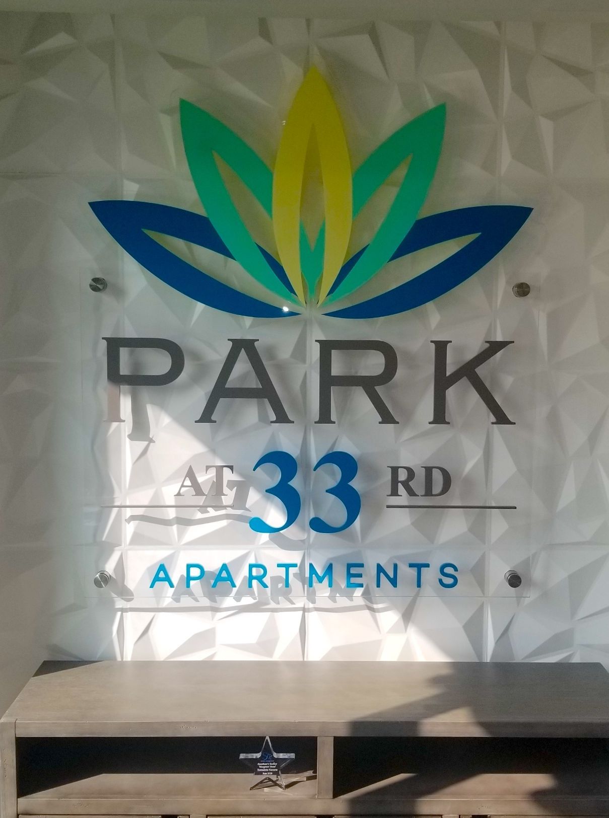 A sign on a wall that says park at 33rd apartments