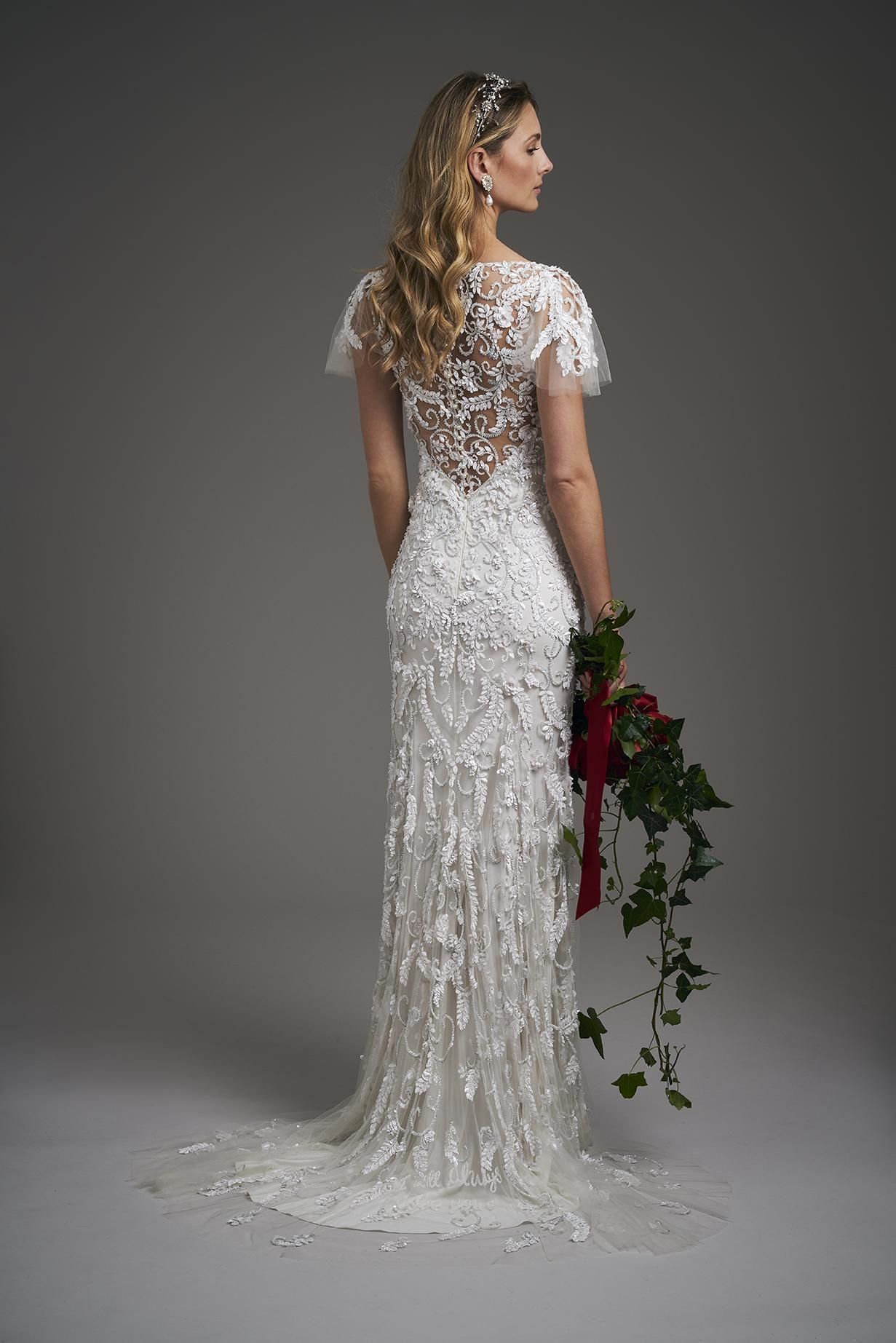 A woman in a white wedding dress is holding a bouquet of flowers.
