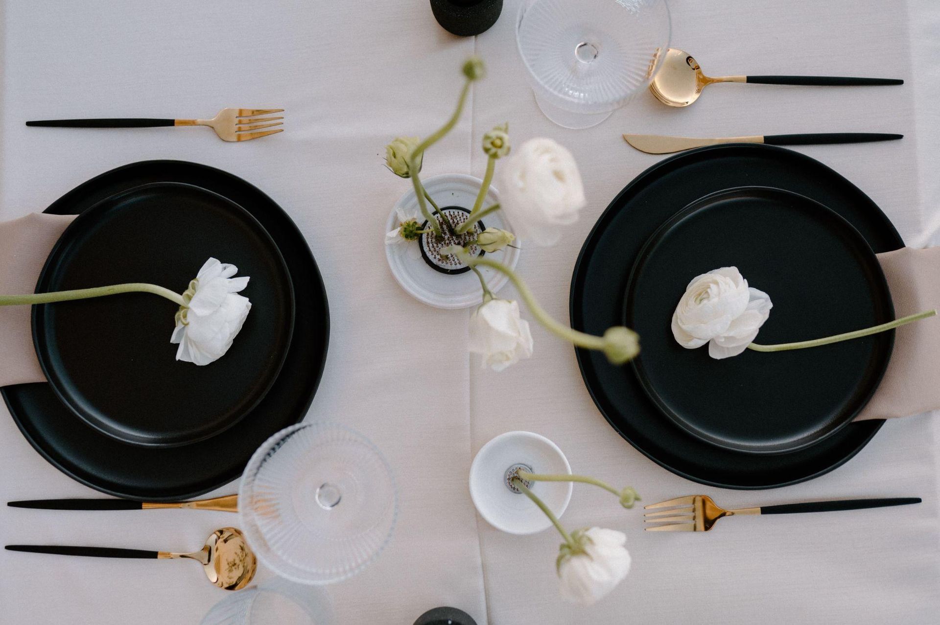 Two black plates with white flowers on them are on a table.