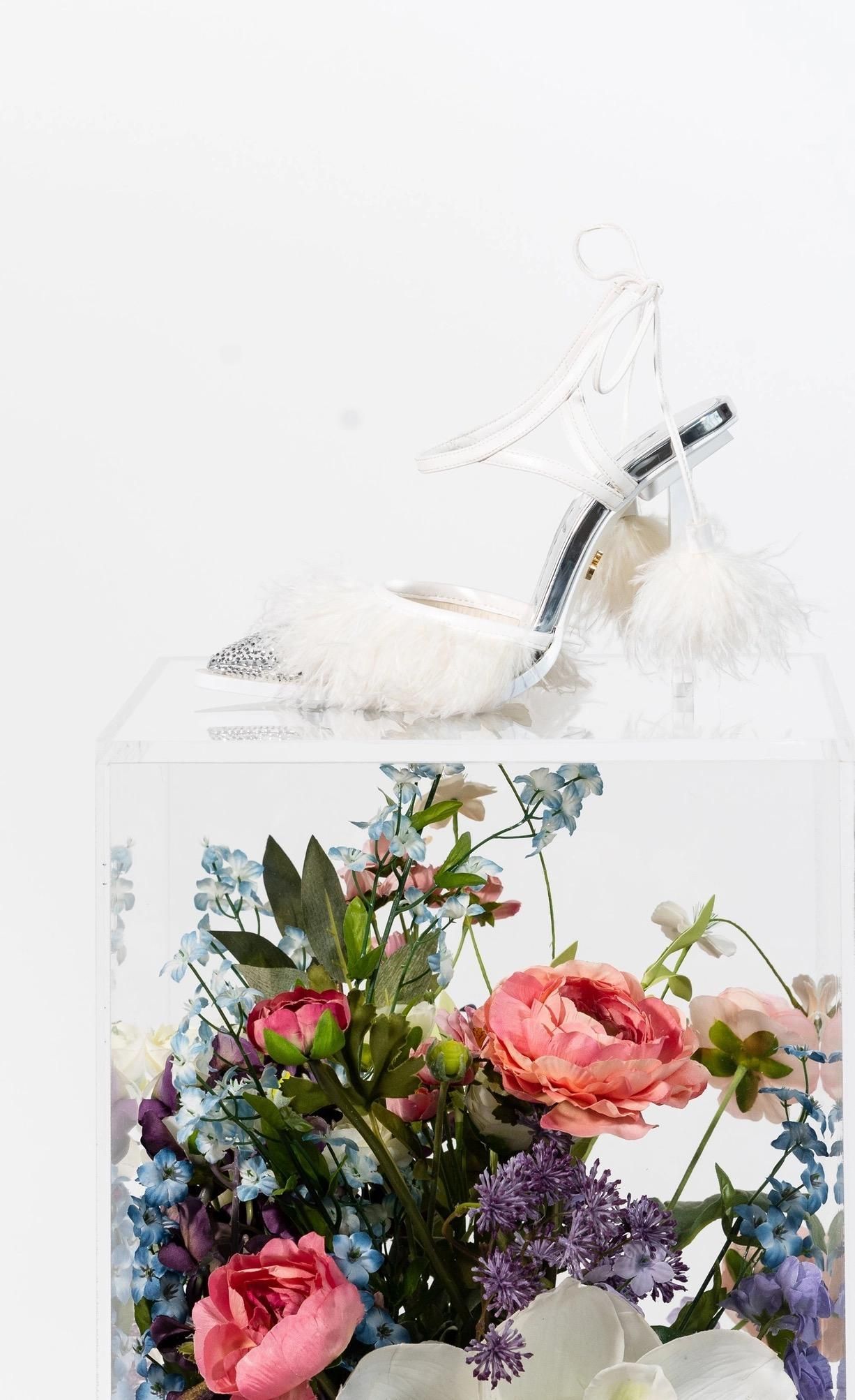 A vase filled with flowers and a shoe in it.