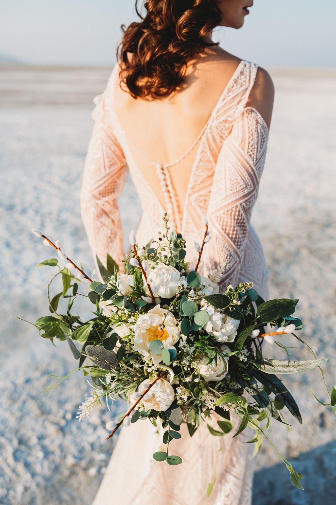 A woman in a wedding dress is holding a bouquet of flowers.
