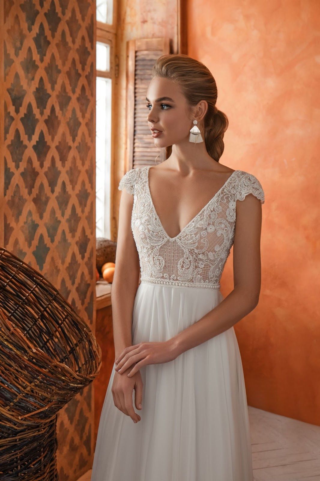A woman is wearing a white wedding dress and earrings.