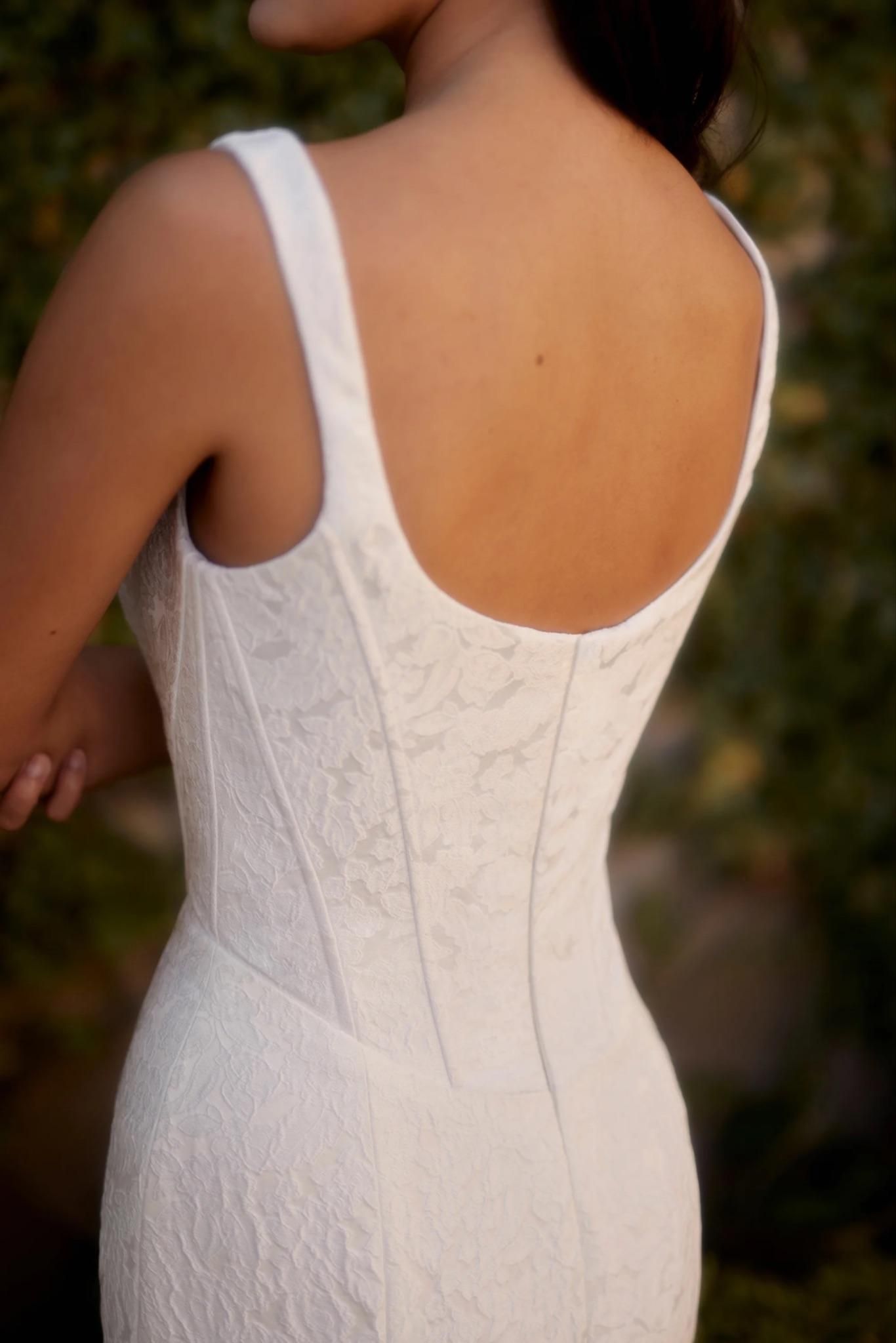 The back of a woman wearing a white dress.