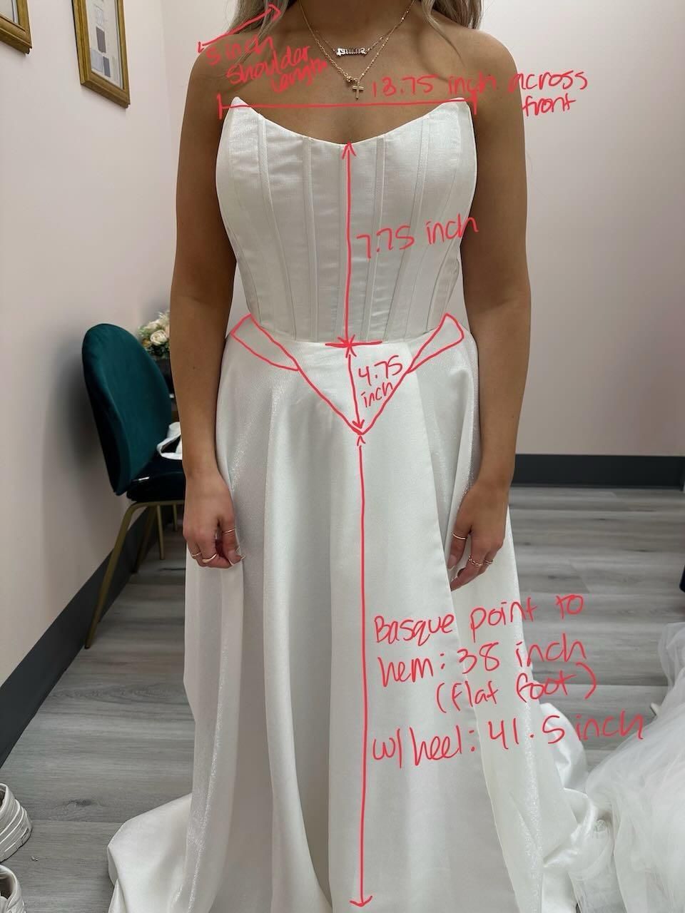A woman in a white wedding dress is standing in a room.