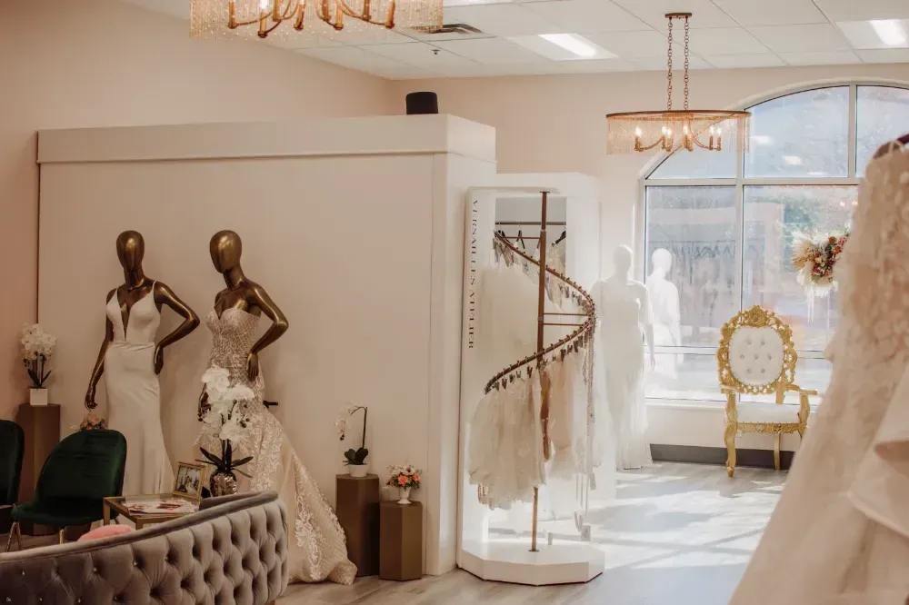 There are many wedding dresses on display in a bridal shop.