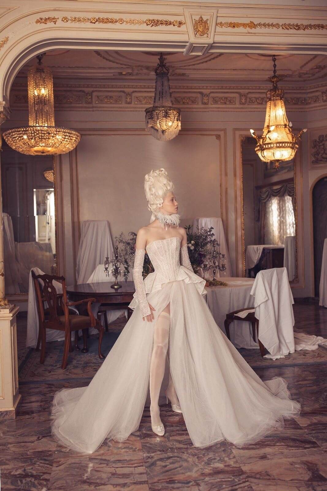 A woman in a wedding dress and wig is standing in a room.