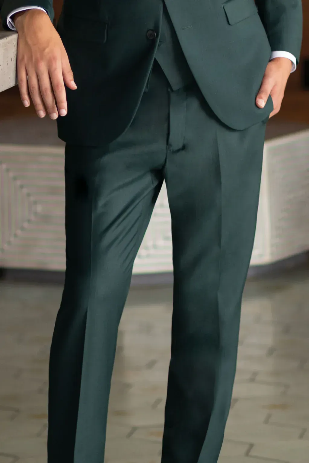 A man in a green suit is standing in front of a counter