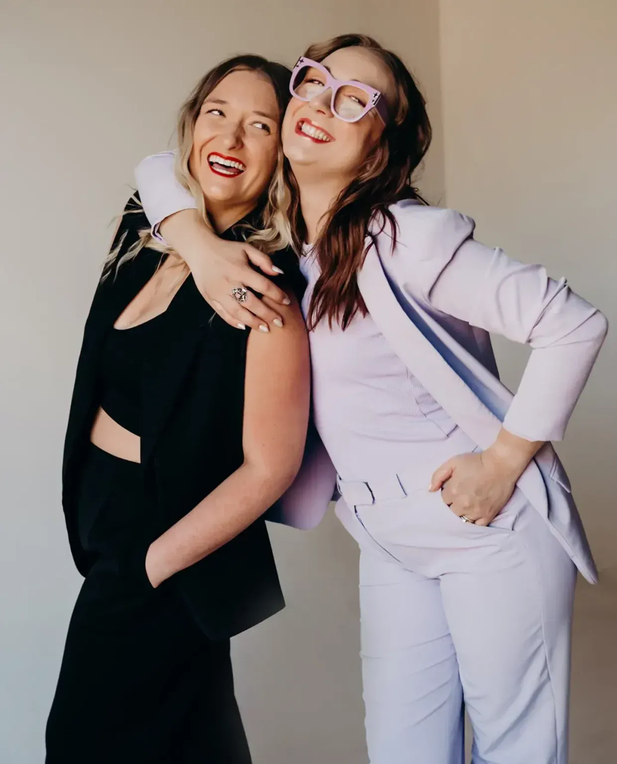 Two women are posing for a picture and one is wearing sunglasses