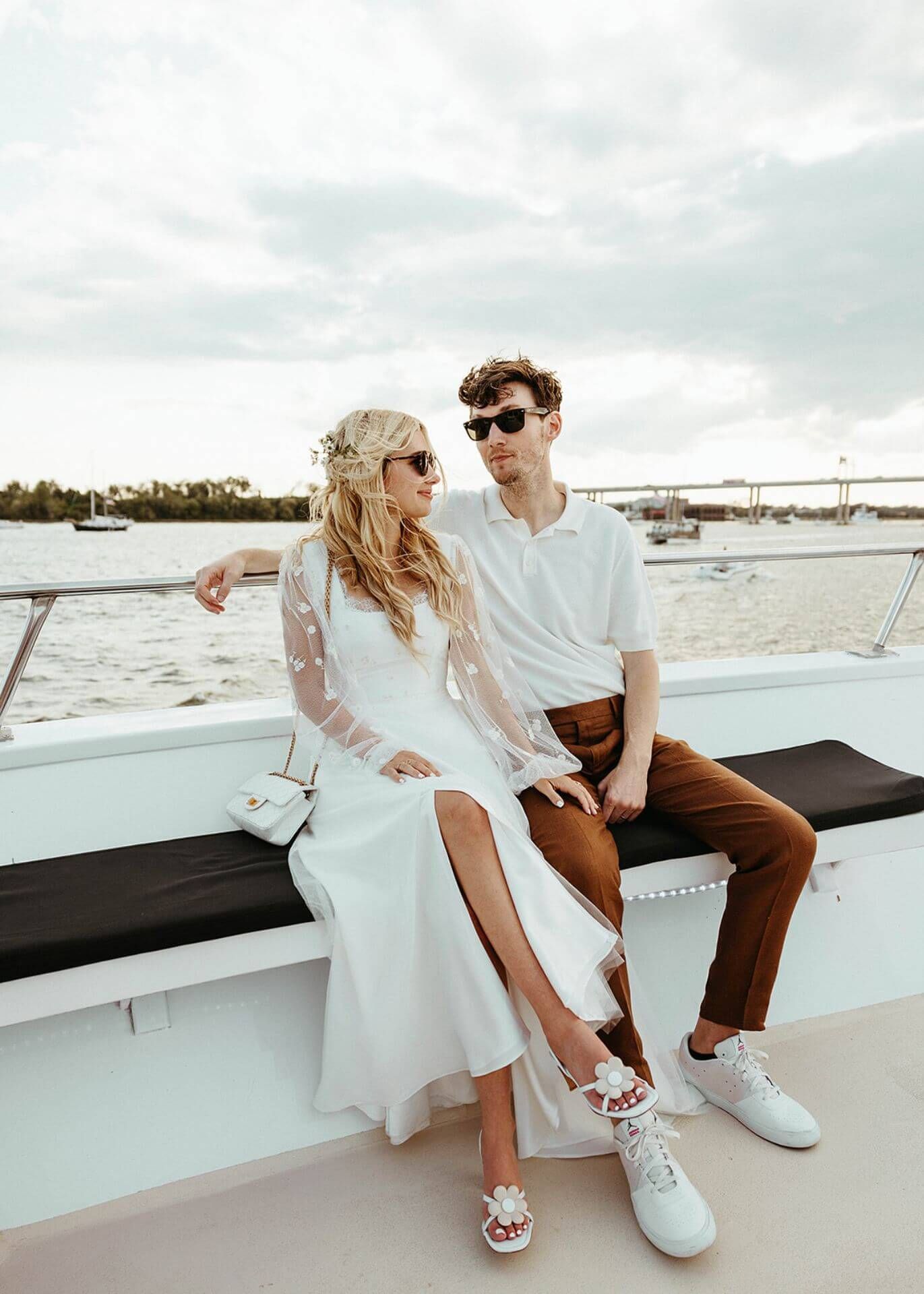 A bride and groom are sitting on a boat in the water.