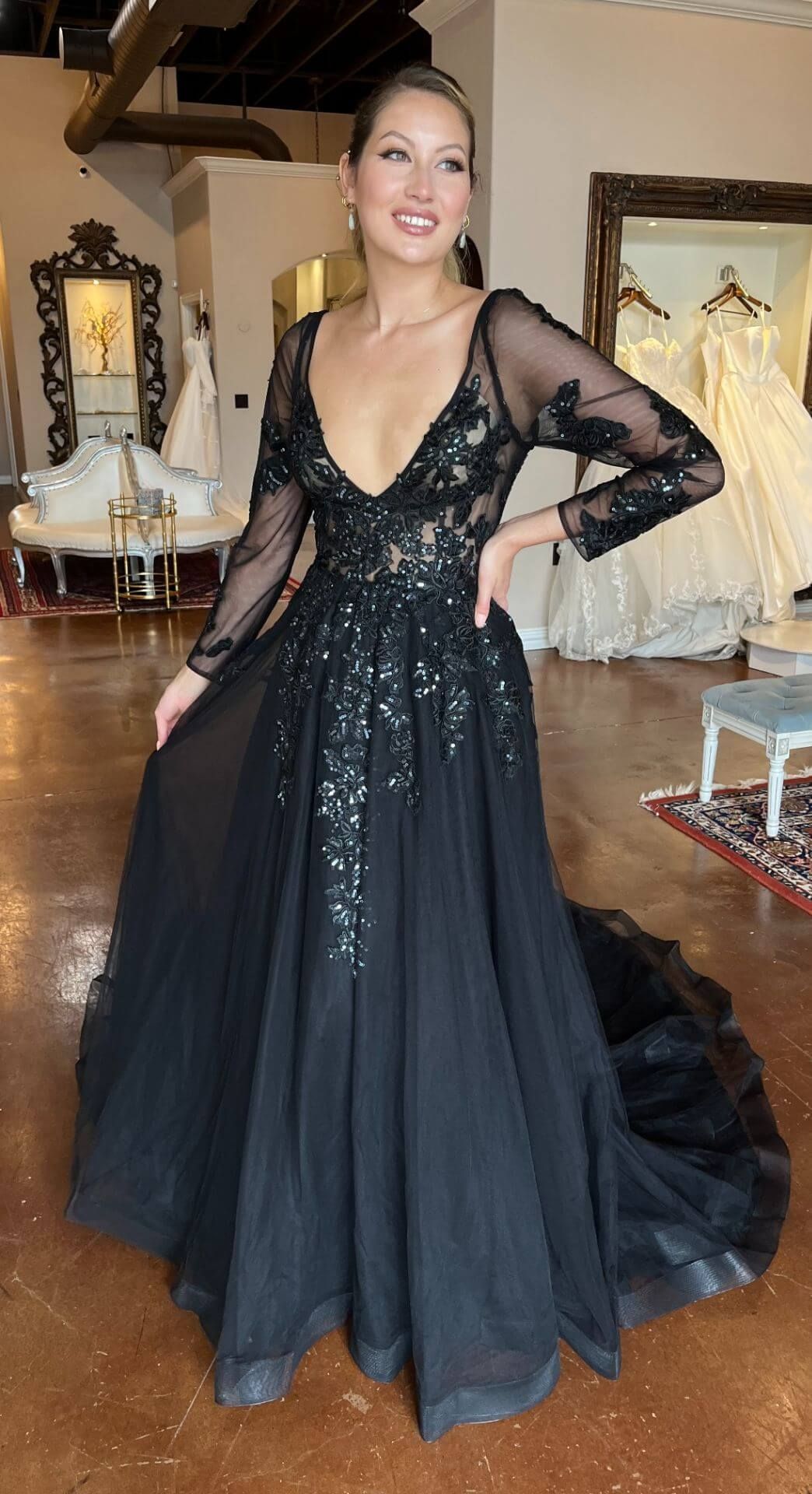 A woman in a black dress is standing in a room.