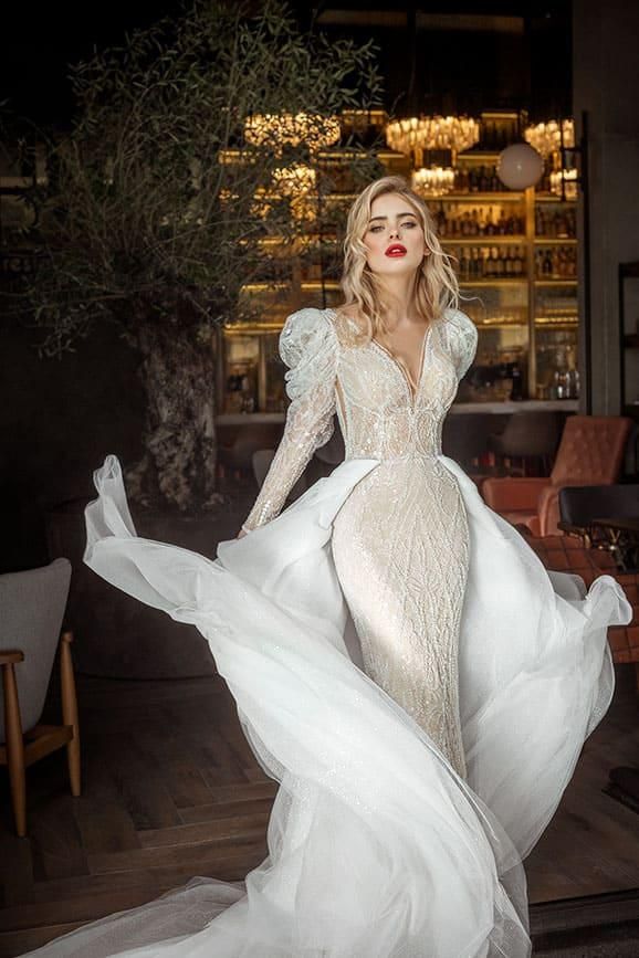 A woman in a wedding dress is standing in a restaurant.