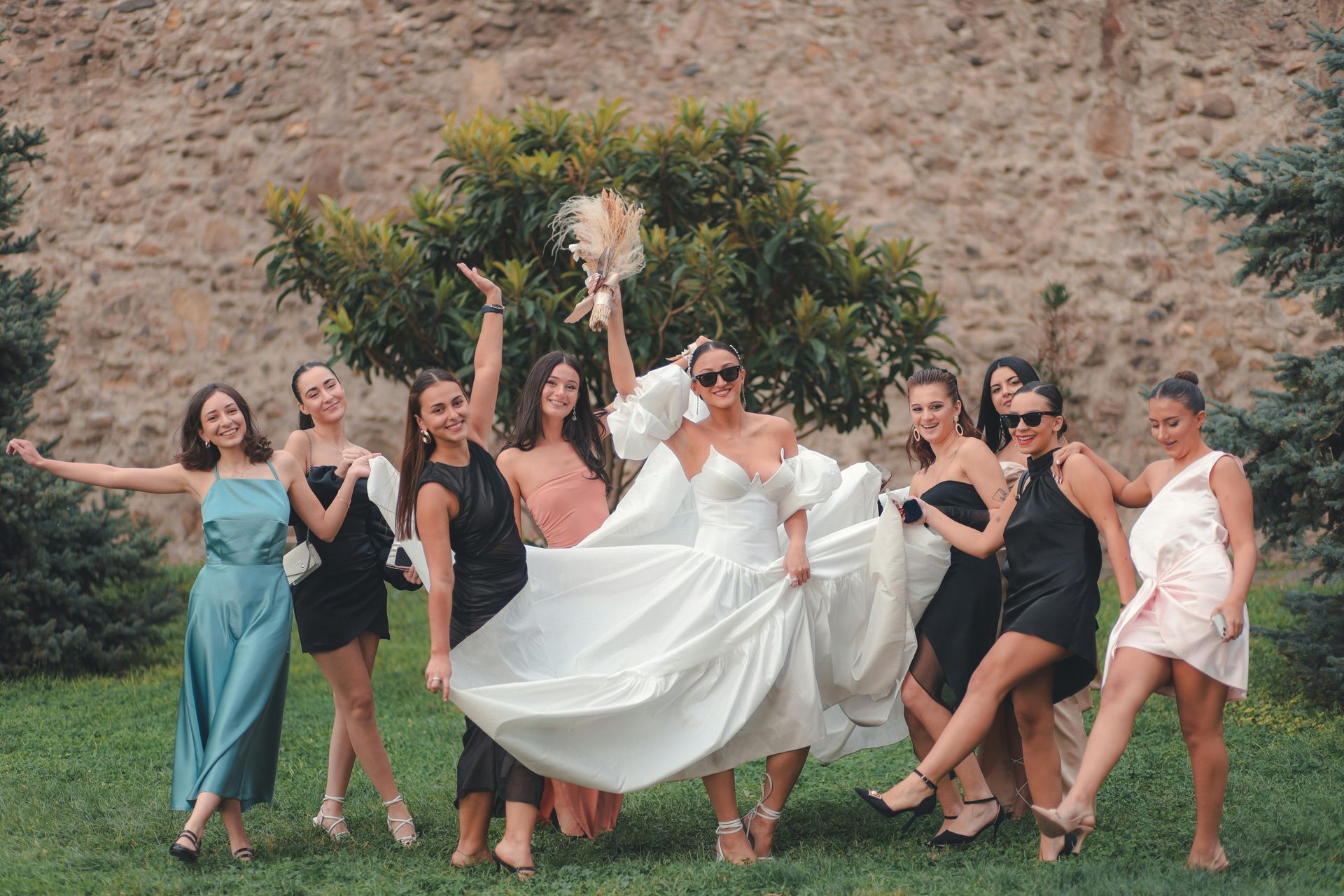 A bride and her bridesmaids are posing for a picture.