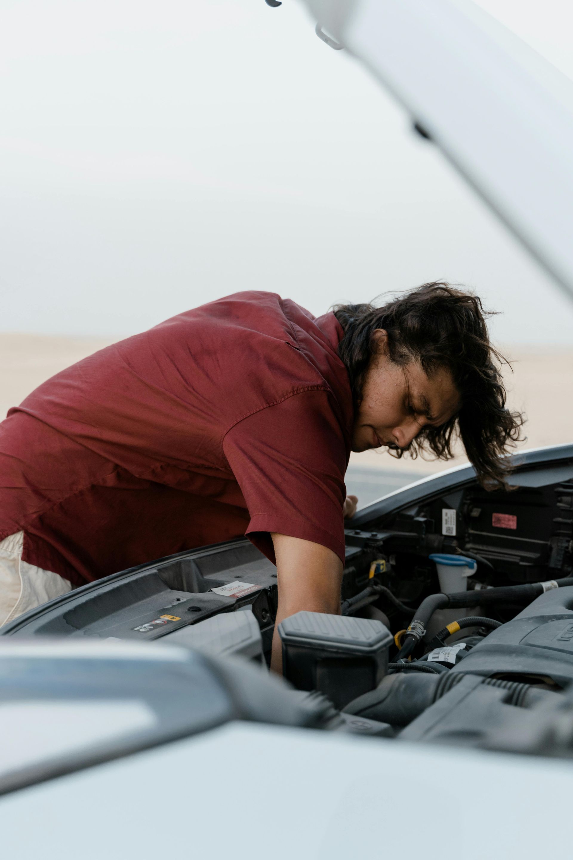 driver checking car engine to cool it down on a hot day