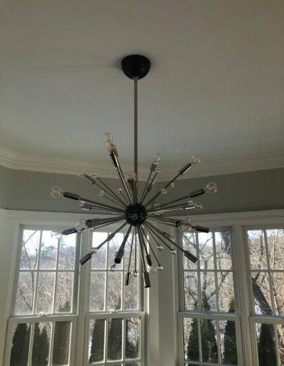 Mid-century modern style chandelier with multiple light fixtures hanging from a ceiling.