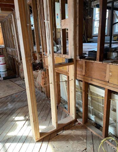Interior framing of a building during renovation, with exposed wooden studs and partially installed walls.