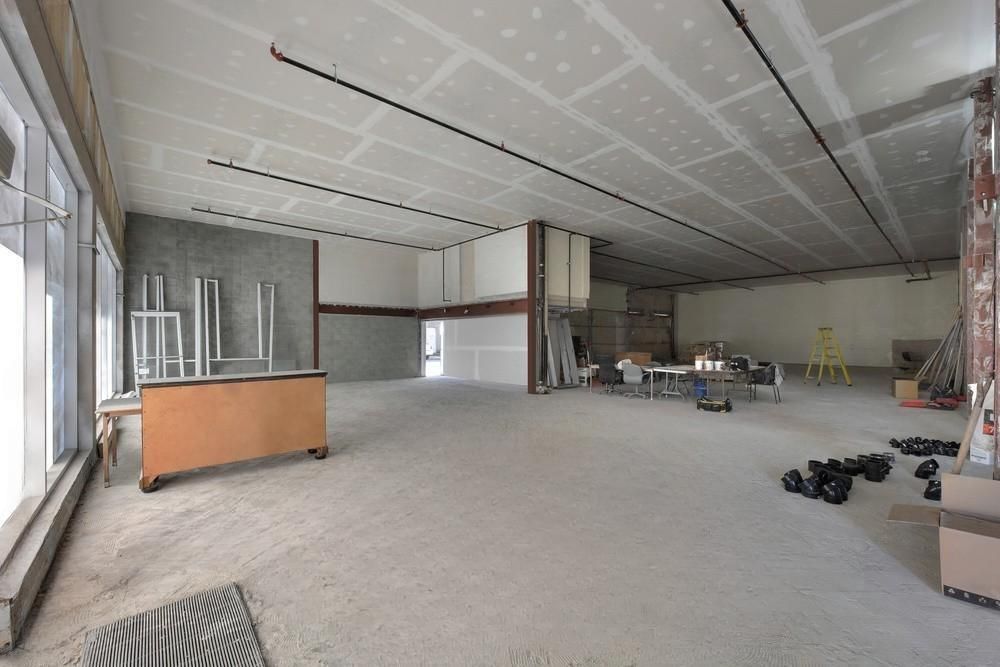 A large empty room with a wooden table in the middle of it.