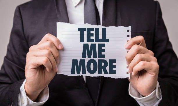 Man in a suit holding a paper sign that reads